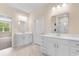 Bright bathroom featuring double vanities, marble floors, white cabinets, and neutral paint at 736 Flowering Branch Ave., Little River, SC 29566
