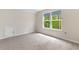 Carpeted bedroom featuring a window with green outdoor views and a storage door at 736 Flowering Branch Ave., Little River, SC 29566