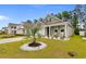 House featuring a well-manicured lawn, plants, a palm tree, and rocking chairs on porch at 736 Flowering Branch Ave., Little River, SC 29566