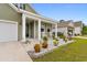 Charming home exterior with decorative landscaping, rocking chairs, and green siding at 736 Flowering Branch Ave., Little River, SC 29566