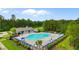Community pool with lounge chairs and tables under blue umbrellas surrounded by green trees at 736 Flowering Branch Ave., Little River, SC 29566