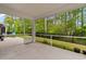 Screened porch with ceiling and outdoor views of wooded backyard and grass at 736 Flowering Branch Ave., Little River, SC 29566