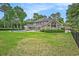 Expansive backyard featuring a pool, patio, lush lawn, mature trees, and beautiful landscaping at 78 Oakmont Dr., Pawleys Island, SC 29585