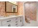 Bathroom showcasing white vanity with gold fixtures and patterned wallpaper at 78 Oakmont Dr., Pawleys Island, SC 29585