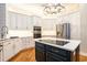 Stylish kitchen with white cabinetry, a center island cooktop, stainless steel appliances, and modern lighting at 78 Oakmont Dr., Pawleys Island, SC 29585