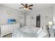 Bright bedroom featuring plush carpet, fan, TV, and a view of the attached bathroom at 802 Devon Estate Ave., Myrtle Beach, SC 29588
