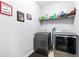Modern laundry room with gray front-loading washer and dryer, wire shelving, and tile flooring at 802 Devon Estate Ave., Myrtle Beach, SC 29588