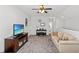 Cozy living room features a beige sofa, television, media console, and a piano at 802 Devon Estate Ave., Myrtle Beach, SC 29588