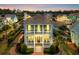Charming two-story home featuring double porches and manicured landscaping at sunset at 8185 Sandlapper Way, Myrtle Beach, SC 29572