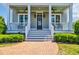 Charming covered porch with rocking chairs and a decorative wreath on the front door at 8185 Sandlapper Way, Myrtle Beach, SC 29572