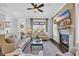 Bright living room featuring a fireplace with TV, comfortable sofas, and a ceiling fan at 8185 Sandlapper Way, Myrtle Beach, SC 29572