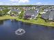 Beautiful backyard with view of a tranquil lake with fountain surrounded by neighborhood homes and verdant trees at 8204 Caddis Ct., Myrtle Beach, SC 29579