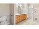 Bright bathroom with wood vanity, marble countertop, oval mirror, and ceramic tile flooring at 8204 Caddis Ct., Myrtle Beach, SC 29579