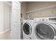 Well-equipped laundry room with modern washer and dryer, shelving, and easy access from the hallway at 8204 Caddis Ct., Myrtle Beach, SC 29579