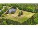 Beautiful aerial view of a large property with a pond, open fields, and surrounding woodlands at 856 W Highway 9, Longs, SC 29568