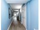 Hallway with wood floors, blue walls and white trim leads to a bedroom or bathroom at 8560 Queensway Blvd. # 1109, Myrtle Beach, SC 29572