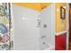 Clean bathroom featuring a white tiled shower and tub combination with bright yellow walls at 908 Wood St., North Myrtle Beach, SC 29582