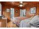 Bedroom with wooden paneling, ceiling fan, and hardwood floors, showcasing an open doorway to another room at 908 Wood St., North Myrtle Beach, SC 29582