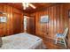 Warm bedroom featuring wood paneling, classic furniture, and open doorway to additional rooms at 908 Wood St., North Myrtle Beach, SC 29582