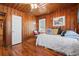 Cozy bedroom featuring wood paneling, a ceiling fan, and ample natural light from the window at 908 Wood St., North Myrtle Beach, SC 29582