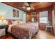 Bedroom featuring wood paneling, a ceiling fan, and a well-lit vanity, with a comfortable bed at 908 Wood St., North Myrtle Beach, SC 29582