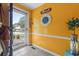 Bright and welcoming entryway with vibrant yellow walls, decorative mirror, and clear front door view at 908 Wood St., North Myrtle Beach, SC 29582