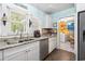 Bright kitchen with stainless steel appliances, and stylish tile flooring, with a view into the laundry room at 908 Wood St., North Myrtle Beach, SC 29582
