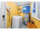 Functional laundry room with washer, dryer, and storage, featuring bright yellow walls at 908 Wood St., North Myrtle Beach, SC 29582