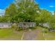Charming home with a tan exterior, blue shutters, and a large shady tree in the front yard at 930 S Marlin Circle, Murrells Inlet, SC 29576