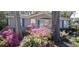 Close up of the home's exterior with pretty pink flowers in front and blue shutters on the windows at 930 S Marlin Circle, Murrells Inlet, SC 29576