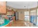 Eat-in kitchen with wood cabinets, green countertops, tile floors, and stainless steel appliances at 930 S Marlin Circle, Murrells Inlet, SC 29576