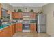 Well-lit kitchen featuring wood cabinets, green countertops, stainless appliances, and tile flooring at 930 S Marlin Circle, Murrells Inlet, SC 29576