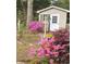 Backyard shed surrounded by flowers and greenery in a well-maintained backyard at 930 S Marlin Circle, Murrells Inlet, SC 29576