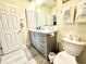 Well-lit bathroom featuring a gray vanity, bright mirror, and tile flooring at 9780 Leyland Dr. # 112, Myrtle Beach, SC 29572