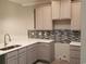 Modern kitchen featuring gray cabinets, quartz countertops, and a stylish mosaic backsplash at Tbd Aft Ct # 101, Murrells Inlet, SC 29576