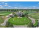 Aerial view of the golf course and clubhouse surrounded by the lake and neighborhood at 1001 World Tour Blvd. # 203, Myrtle Beach, SC 29579