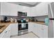 Well-lit kitchen with white cabinets, granite countertops, and stainless steel appliances at 1001 World Tour Blvd. # 203, Myrtle Beach, SC 29579