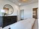 Serene bedroom with a round mirror, wooden dresser, soft carpet, and neutral decor at 1014 Laconic Dr., Myrtle Beach, SC 29588