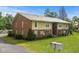 A two-story brick apartment building surrounded by lush green grass and mature trees at 1015 Elm St. # 4, Conway, SC 29526