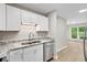 Bright kitchen with white cabinets, stainless steel dishwasher, and view into the living room at 1015 Elm St. # 4, Conway, SC 29526