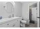 Bright bathroom with a white vanity, round mirror, and access to a tiled shower at 10301 N Kings Hwy. # 10-4, Myrtle Beach, SC 29572