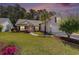 Charming single-Gathering home with lush green lawn, manicured landscaping and a driveway at dusk at 1105 Lampwick Ln., Murrells Inlet, SC 29576