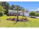 Well-maintained home featuring lush landscaping, palm trees, and a charming walkway at 1105 Lampwick Ln., Murrells Inlet, SC 29576