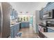 Charming kitchen with blue cabinets, stainless appliances, and views of the sunroom at 1105 Lampwick Ln., Murrells Inlet, SC 29576