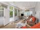 Inviting sunroom with wicker furniture, screened windows, and an open doorway to the exterior at 1105 Lampwick Ln., Murrells Inlet, SC 29576