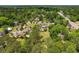 Aerial view of a large, landscaped property with a pool, surrounded by mature trees and neighboring homes at 115 Ford Ave, Mullins, SC 29574