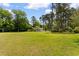 Expansive backyard with a manicured lawn and mature trees, offering privacy and recreational space at 115 Ford Ave, Mullins, SC 29574