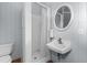 A full bathroom with a shower, toilet, and sink featuring a round mirror and clean fixtures at 115 Ford Ave, Mullins, SC 29574
