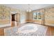 View of dining room with hardwood floors, decorative wallpaper and adjacent rooms at 115 Ford Ave, Mullins, SC 29574