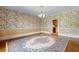 Spacious dining room with hardwood floors, decorative wallpaper, and elegant chandelier lighting at 115 Ford Ave, Mullins, SC 29574